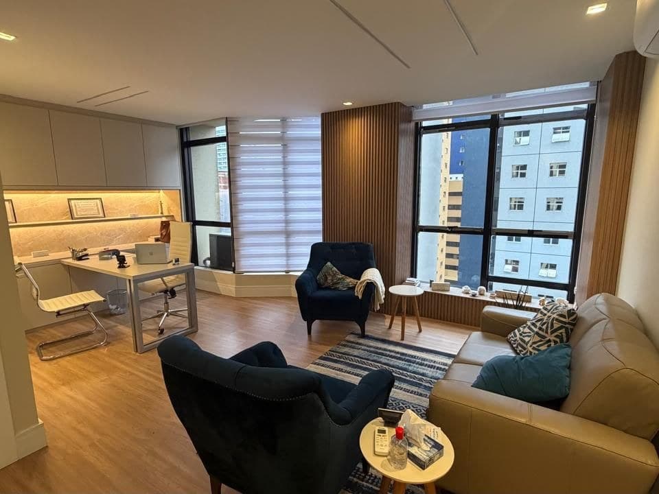 Sala de atendimento da Dra. Isabella Dacroce, com poltronas, sofá, escrivaninha e janelas amplas